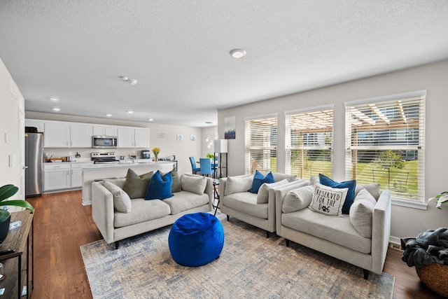 living room featuring recessed lighting, a textured ceiling, and dark wood-style floors