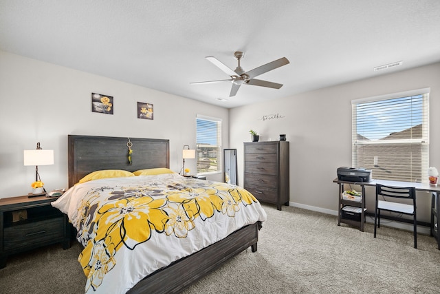 carpeted bedroom with visible vents, baseboards, and ceiling fan