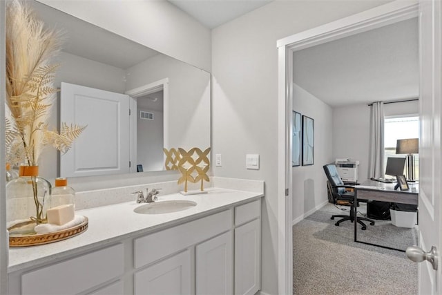 bathroom with vanity, visible vents, and baseboards