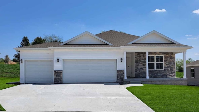 view of front of property featuring a porch, an attached garage, driveway, stone siding, and a front lawn