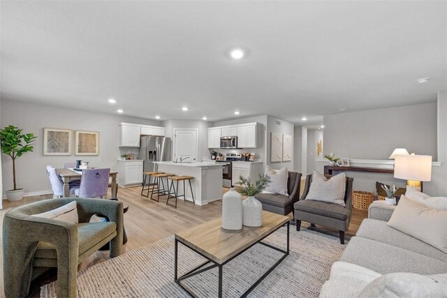 living room with light wood-type flooring and recessed lighting