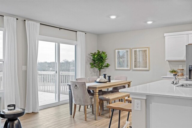 dining area featuring sink and light wood-type flooring