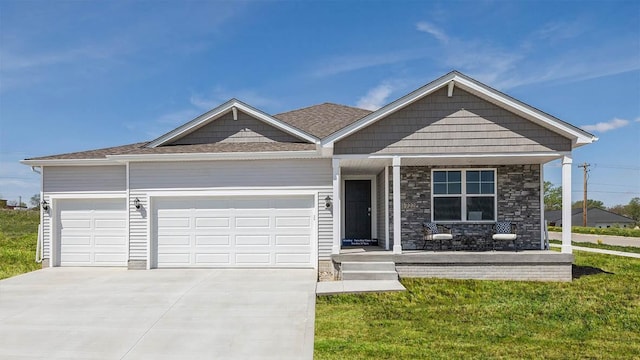 view of front facade with a garage, concrete driveway, covered porch, and a front yard