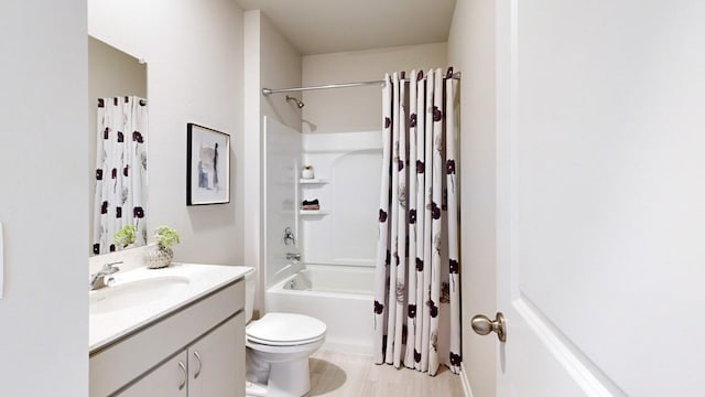 bathroom with shower / bathtub combination with curtain, vanity, and toilet