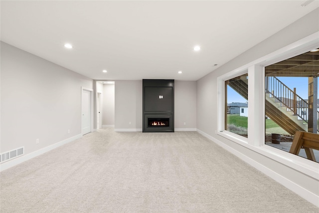 1129 NW 28th St, Grimes, IA 50111 - unfurnished living room featuring a fireplace, light carpet, recessed lighting, and stairway