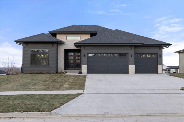 prairie-style house featuring a front yard and a garage