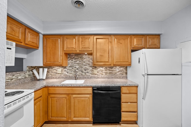 kitchen featuring a textured ceiling, sink, white appliances, and decorative backsplash