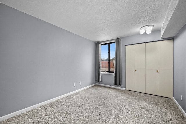 unfurnished bedroom with a closet, light colored carpet, and a textured ceiling