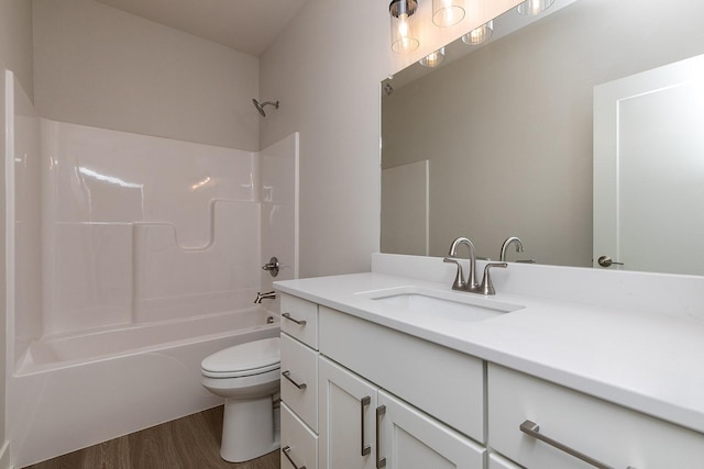 full bath with vanity, shower / bath combination, wood finished floors, and toilet