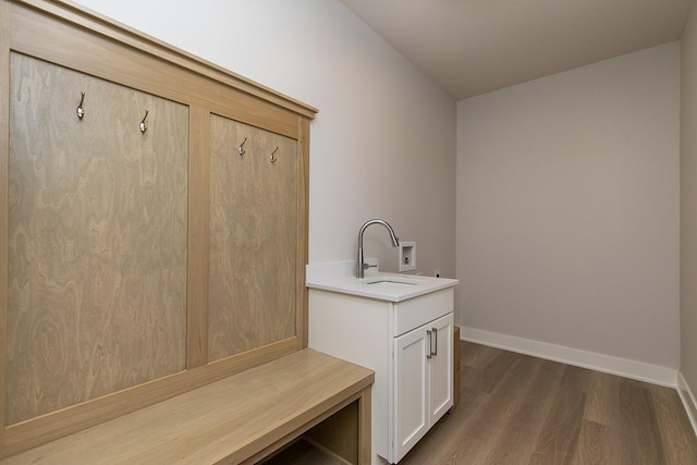 mudroom with baseboards, dark wood-type flooring, and a sink