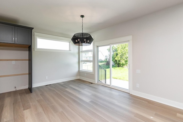 unfurnished dining area with light wood finished floors and baseboards