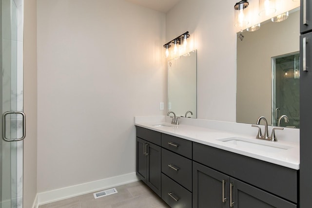 full bathroom with a stall shower, visible vents, a sink, and baseboards