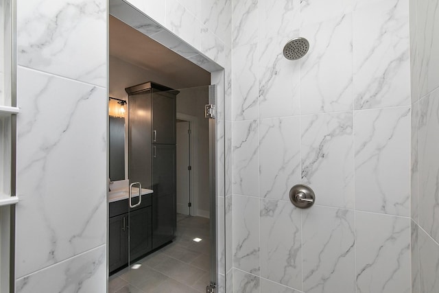 bathroom featuring vanity and a marble finish shower