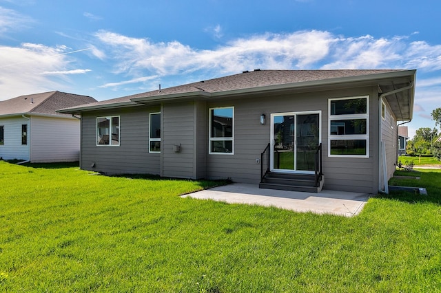 back of property with entry steps, a patio, and a lawn