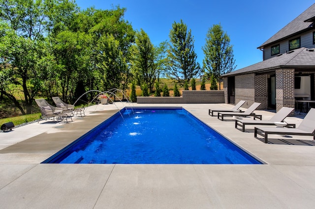 view of pool with a patio and pool water feature