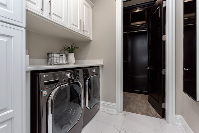 washroom featuring washing machine and clothes dryer and cabinets