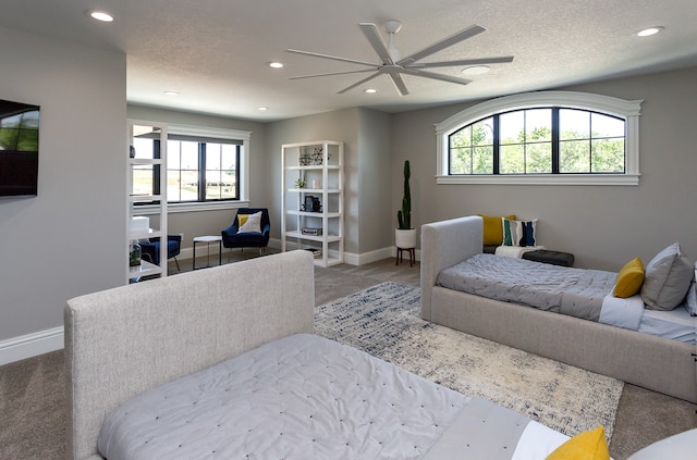 carpeted bedroom featuring a textured ceiling and ceiling fan