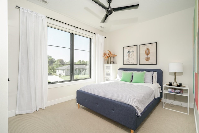 carpeted bedroom with ceiling fan and multiple windows