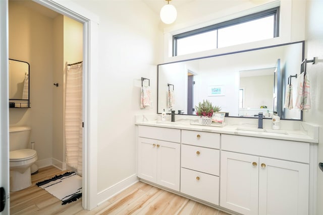 bathroom with walk in shower, hardwood / wood-style floors, vanity, and toilet