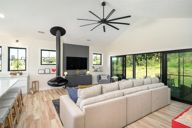 living room with ceiling fan, high vaulted ceiling, and light hardwood / wood-style floors