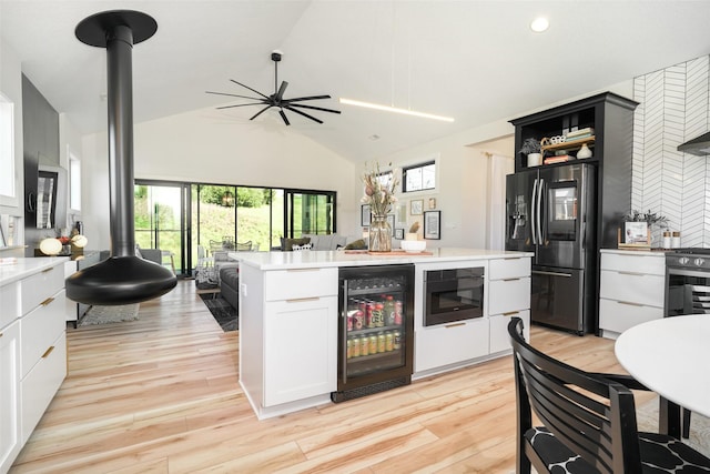 kitchen featuring fridge with ice dispenser, white cabinetry, beverage cooler, vaulted ceiling, and a kitchen island