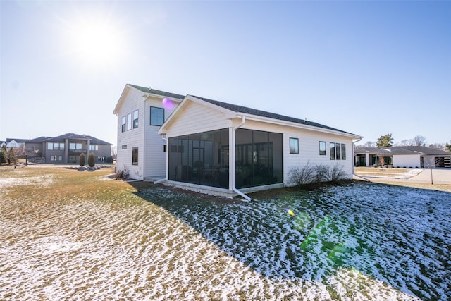 back of house featuring a sunroom and a lawn