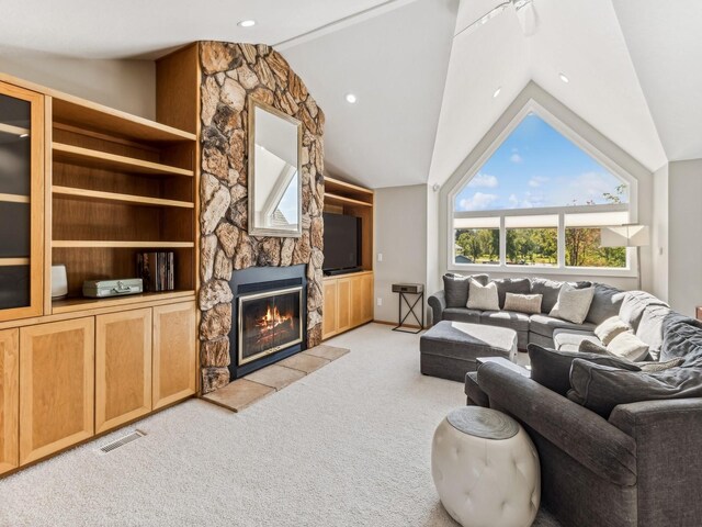 carpeted living room with ceiling fan, a fireplace, and vaulted ceiling