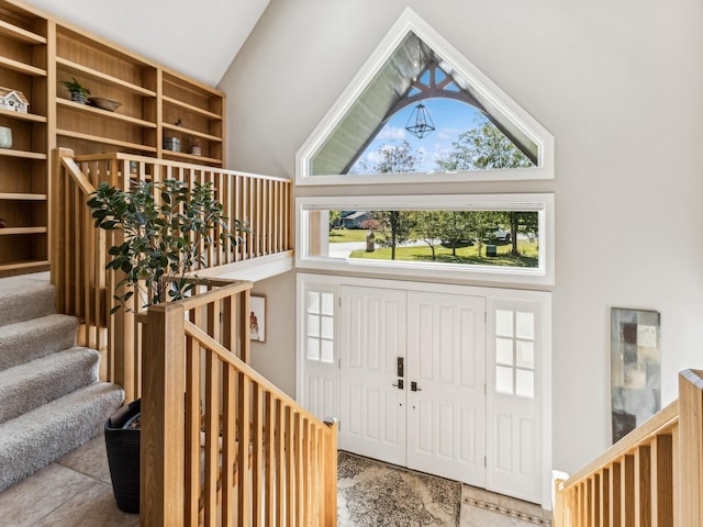 tiled foyer with high vaulted ceiling and stairway