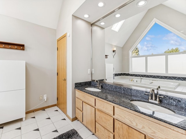 bathroom featuring lofted ceiling with skylight, a sink, a tub to relax in, and double vanity