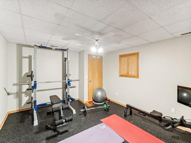 exercise area with a drop ceiling, ceiling fan, visible vents, and baseboards