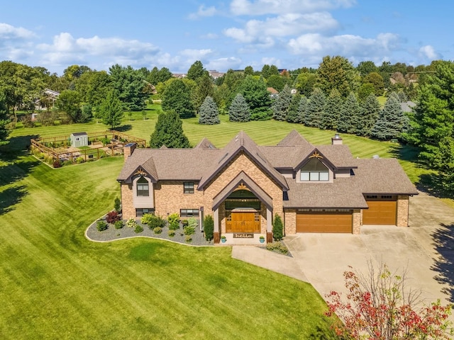 view of front of house with brick siding, an attached garage, driveway, and a front lawn