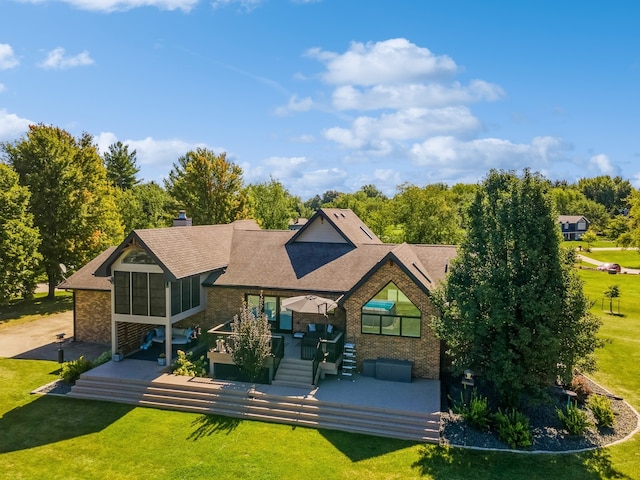 rear view of house featuring a sunroom, a lawn, and a patio area