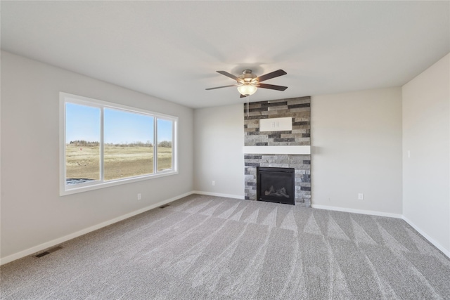 unfurnished living room with ceiling fan, a fireplace, and carpet