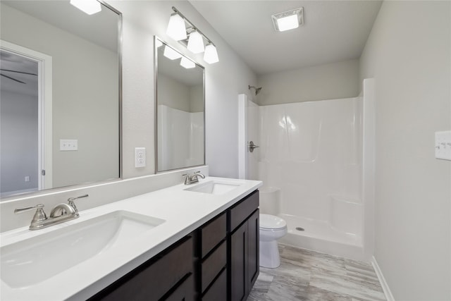 bathroom with a shower, vanity, and toilet