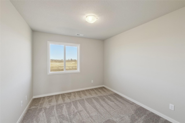 carpeted spare room featuring a textured ceiling