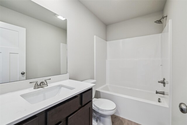 full bathroom with vanity, wood-type flooring,  shower combination, and toilet