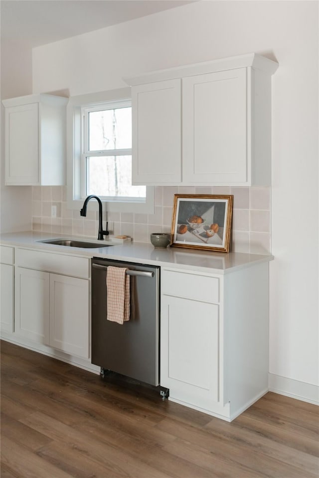 kitchen with white cabinetry, dishwasher, sink, dark wood-type flooring, and tasteful backsplash