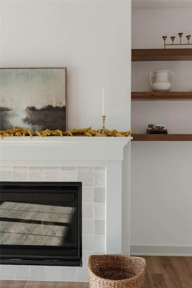 details featuring a tile fireplace and hardwood / wood-style flooring