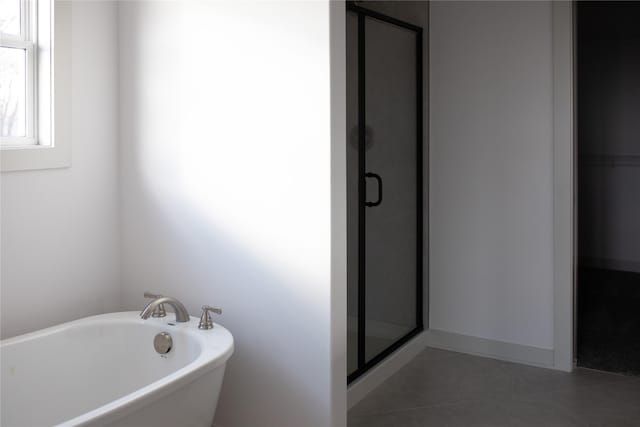 bathroom with separate shower and tub and tile patterned flooring