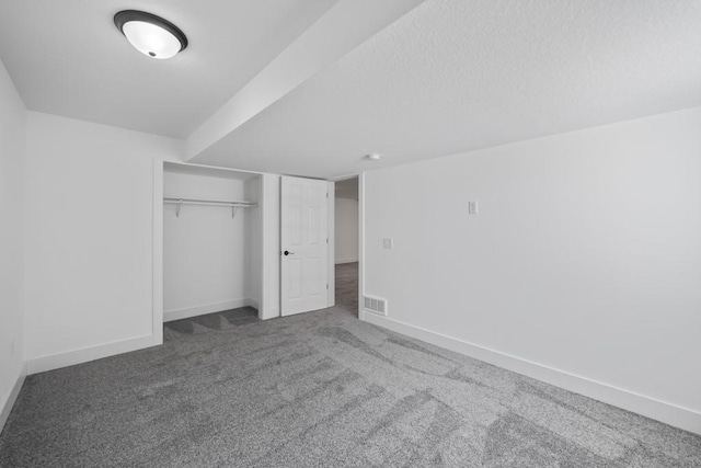 unfurnished bedroom with carpet flooring, baseboards, visible vents, and a closet