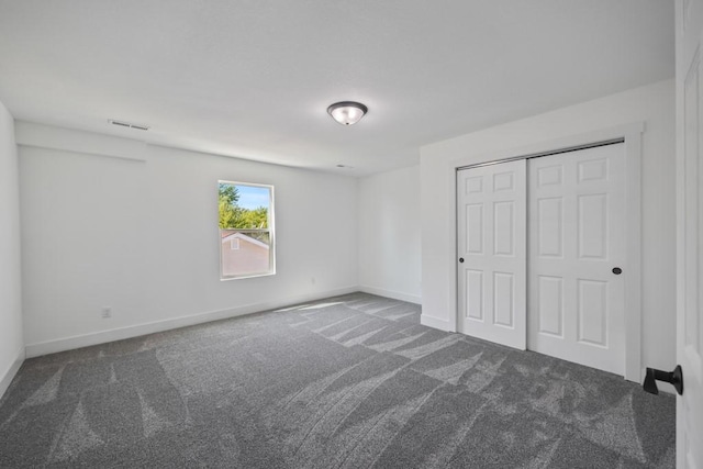 unfurnished bedroom with baseboards, a closet, and carpet floors