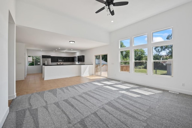 unfurnished living room with light tile patterned floors, baseboards, recessed lighting, ceiling fan, and light carpet