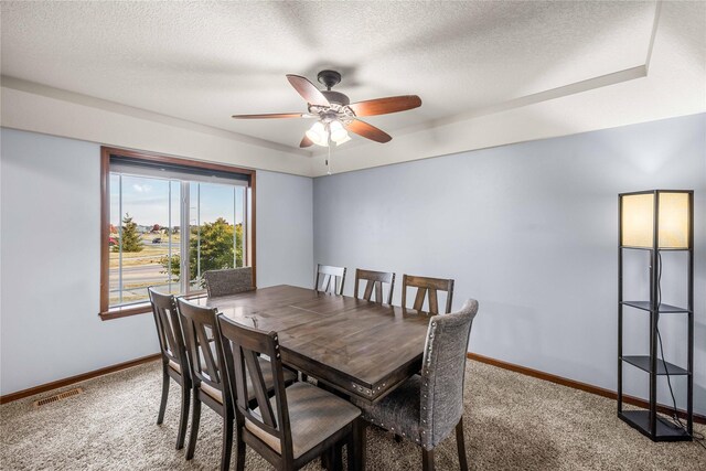 dining area with ceiling fan, carpet floors, and a textured ceiling