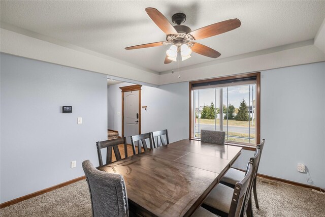 dining area with carpet, ceiling fan, and a textured ceiling