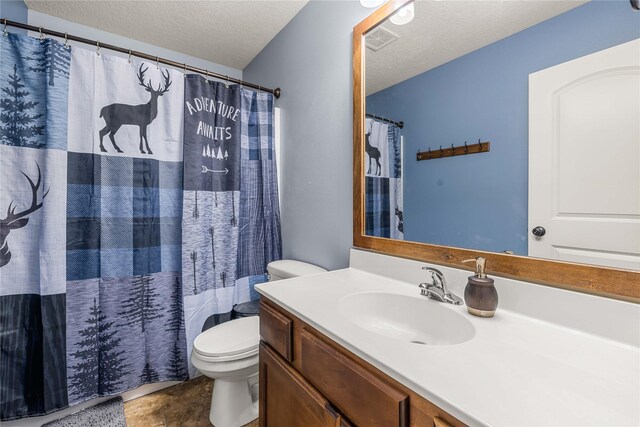 bathroom featuring walk in shower, vanity, a textured ceiling, and toilet