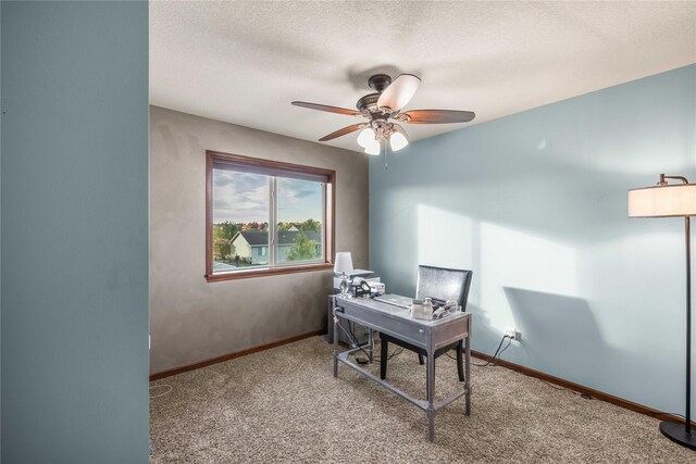 carpeted office space featuring ceiling fan and a textured ceiling