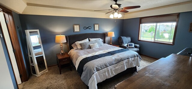 bedroom with ceiling fan, a raised ceiling, and carpet floors