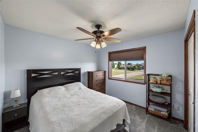 carpeted bedroom featuring ceiling fan and a textured ceiling