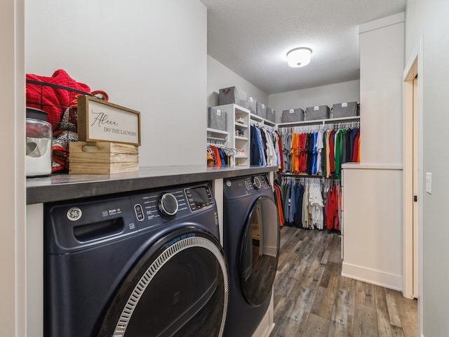 washroom with hardwood / wood-style floors, a textured ceiling, and independent washer and dryer