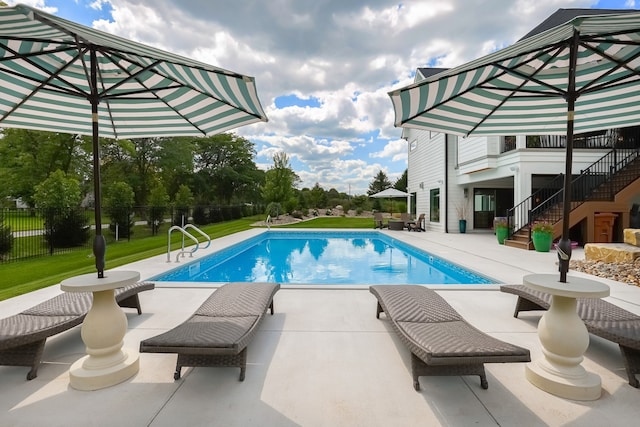 view of pool featuring a lawn and a patio